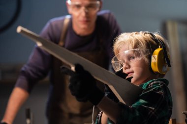 Küçük bir çocuk, bir marangoz dükkanında tüfeğin ahşap bir modelini yaptı ve onunla oynadı..