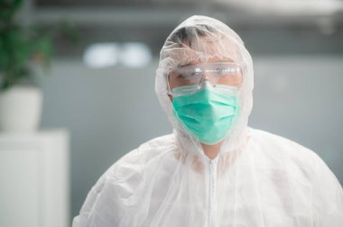 Tanınmayan bir doktorun portresi. Koruyucu giysisi ve maskesi var.