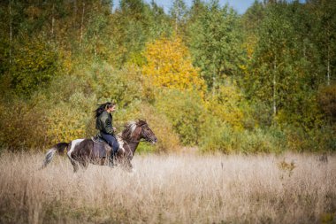 Sıcak bir sonbahar gününde, genç bir kız atıyla çiftliğin etrafında dolaşmaya çıktı.