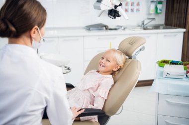 Genç bir dişçi hastalarının dişlerini ayrıntılı bir şekilde kontrol ediyor.