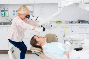 Hastanedeki çocuklar, küçük doktorlar, dişçiyi oynuyorlar.