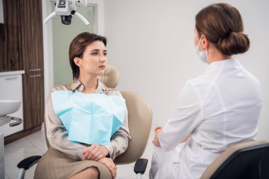 Kadın bir dişçi hastalarına danışmanlık yapıyor.