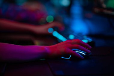 Oyuncuların yakın plan el hareketleri parlayan klavye ve fare üzerinde