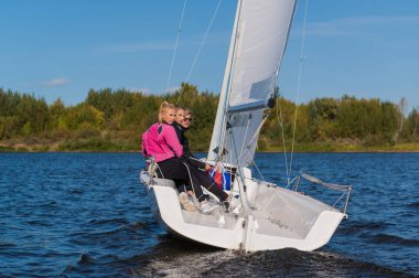 Genç bir adam ve iki güzel kız gölde bir haftasonu gezisi için beyaz bir yatla rıhtımdan yola çıktılar.