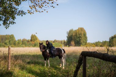 Şirin kız binicilik hocası binicilik kulübünde ata biniyor.