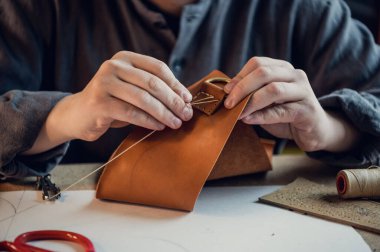 Ayakkabı atölyesinde çalışan genç bir zanaatkarın özel deri ayakkabılar üretmesi.