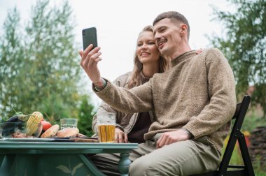 Evin yakınındaki bahçelerinde yaşayan genç bir çift, aileleriyle birlikte akıllı telefondan telefon aracılığıyla iletişim kuruyor ve evlilik yıldönümleri için onları tebrik ediyor. Tatil masası, piknik..