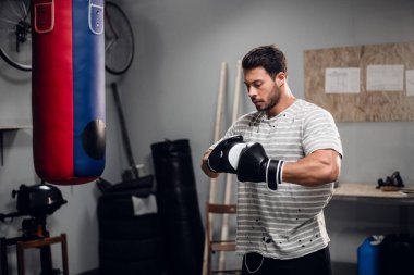 Deneyimli bir sporcu garajında boks antrenmanından önce ısınmaya hazırlanır..