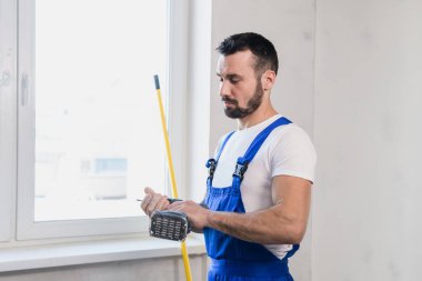 Mezura ile üniformalı bir inşaatçı