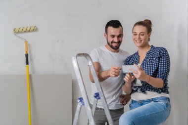 Merdivende oturan ve cep telefonundaki fotoğraflara bakan çift.