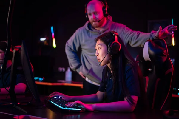 Teknik direktör, beyaz adam ve Asyalı kızla bilgisayar kulübünde Esports takımı eğitim kampı.