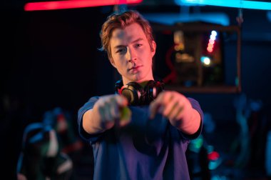 Boynuna kulaklık takmış havalı bir oyuncu ellerini kameraya gösteriyor ve sizi bir bilgisayar oyununa davet ediyor.