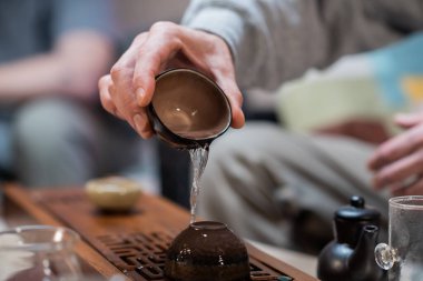 Geleneksel Çin çayı demleme aşaması. Bulanık arkaplanı olan özel bir bambu tahtasında Clay Bardakları..