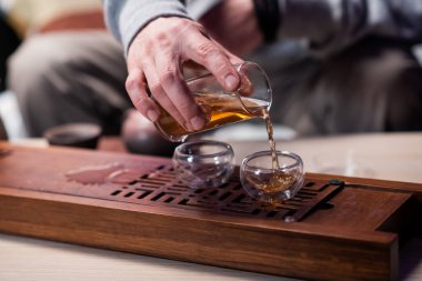 Çin geleneklerine göre lezzetli bir siyah çay tarifi. Çay için cam ve kil tabakları yakın çekim. Sürahiler ve çaydanlıklar.