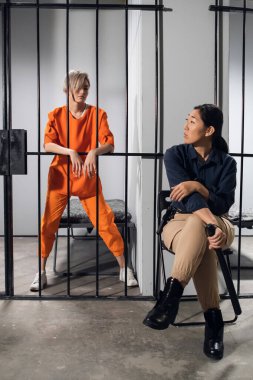 Genç bir suçlu ve kadın gardiyanı hapishanede fotoğraf çektirmek için poz veriyorlar.