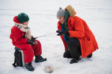 Baba ve oğul kışın kırmızı elbiseleriyle nehir kıyısında balık tutmaya gelirlerdi.