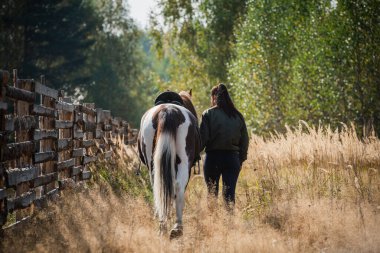 Sonbaharda çiftlikte at taşıyan bir kızı gezdiriyorum.