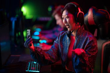 Güzel bir flamalı kız, Esport oyuncuları arasında dota turnuvasındaki bir seğirmeyle yayın yapıyor.
