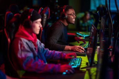 Uluslararası oyun etkinliği. Esport yarışmaları için arena. Kulaklıklı genç oyuncular popüler bir online oyun oynuyorlar.