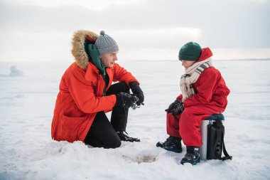 Baba ve oğul kışın kırmızı elbiseleriyle nehir kıyısında balık tutmaya gelirlerdi.