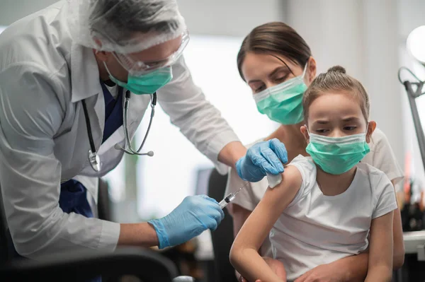 stock image A caring mother brought her daughter to the vaccination office to get vaccinated, the girl is afraid