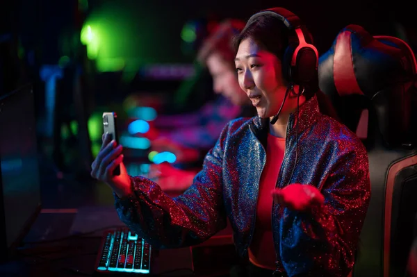 A pretty streamer girl is broadcasting on twitch from a dota tournament among esports players — Stock Photo, Image