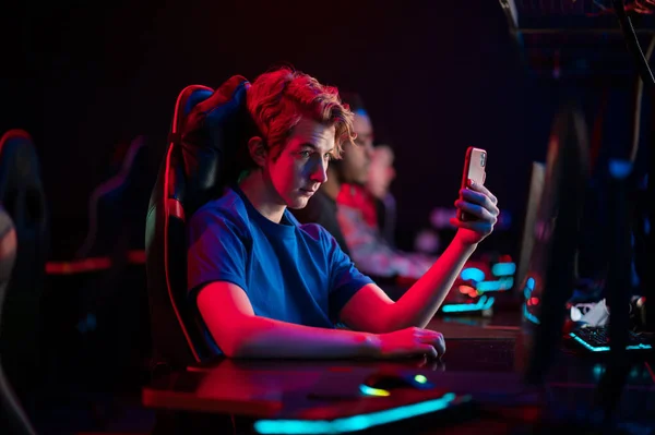 A cute gamer went live on twitch from a smartphone and shows the training process of gamers in a computer club — Stock Photo, Image