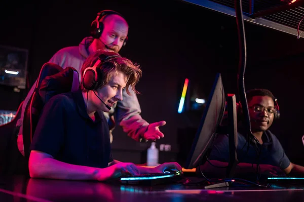 Tijdens een computerspelletjes toernooi, een jonge man is nerveus, de coach vertelt hem de tactiek van het gevecht — Stockfoto