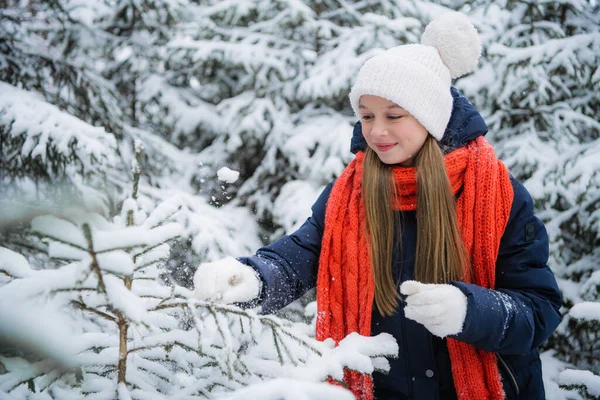 Uma jovem encantadora desfruta das férias de ano novo e da primeira neve na floresta. — Fotografia de Stock