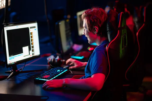 Uluslararası oyun etkinliği. Esport yarışmaları için arena. Kulaklıklı genç oyuncular popüler bir online oyun oynuyorlar.