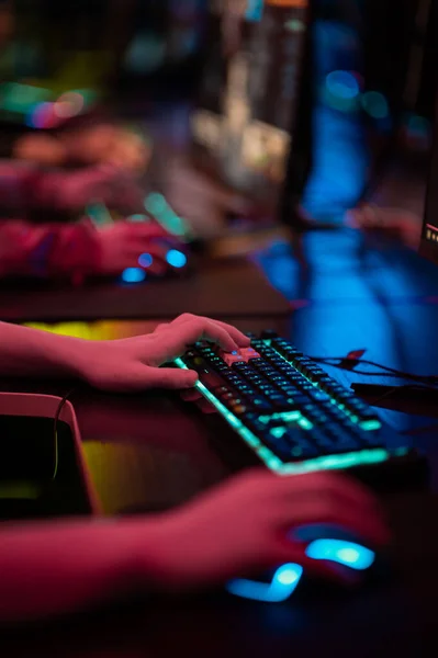 Close-up of the gamers hand movements on the glowing keyboard and mouse — Stock Photo, Image