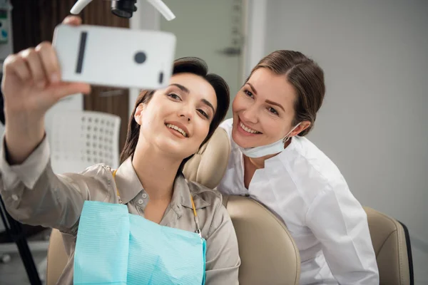 Εικόνα μιας όμορφης χαρούμενης νεαρής γυναίκας που κάθεται στην ιατρική οδοντιατρική — Φωτογραφία Αρχείου