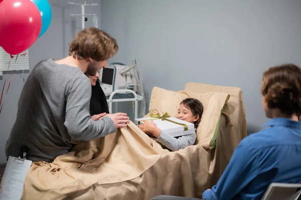 Una fiesta de cumpleaños en un hospital, una niña sonriente, está recibiendo regalos — Foto de Stock