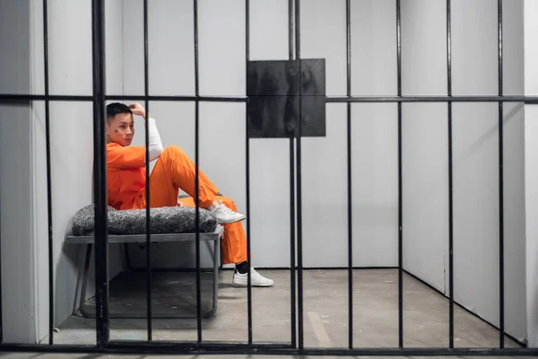 Aziatische crimineel met tatoeages op zijn gezicht in een cel heeft berouw van de misdaad. Depressie van een gevangene in de gevangenis. — Stockfoto