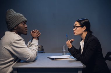 Zarif takım elbiseli güzel bir araştırmacı kız siyah bir suçludan soruşturmada işbirliği yapmasını ve itiraf imzalamasını istiyor..