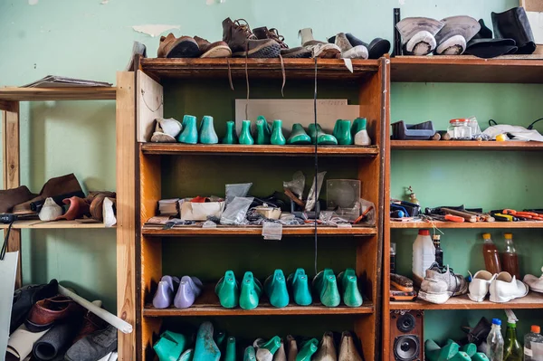 Coloridos espacios en blanco para los zapatos están en los estantes en el gabinete en el estudio de producción de zapatos —  Fotos de Stock
