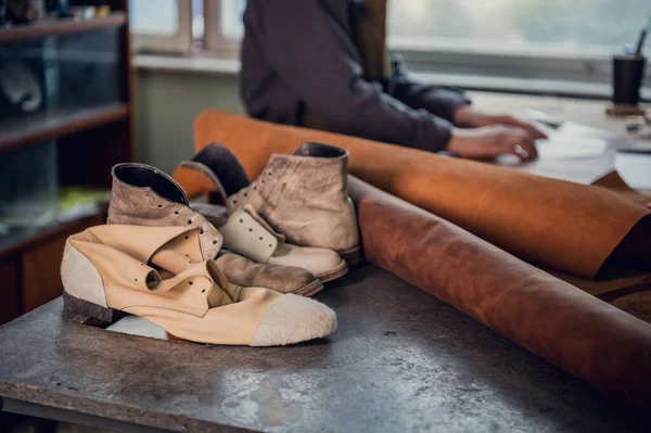 Especialista experimentado en la producción de cuero de calzado pone en una mesa en su taller —  Fotos de Stock