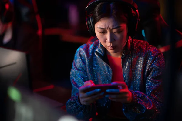 The chinese gamer girl decided to take a break and play on her smartphone, she is tired, losing and upset — Stock Photo, Image