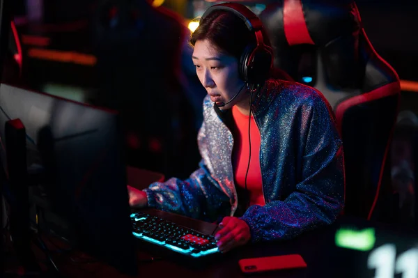 Training of esports players in a bootcamp. A young asian gamer at a powerful gaming PC looks at the monitor. Online cyber sports. — Stock Photo, Image