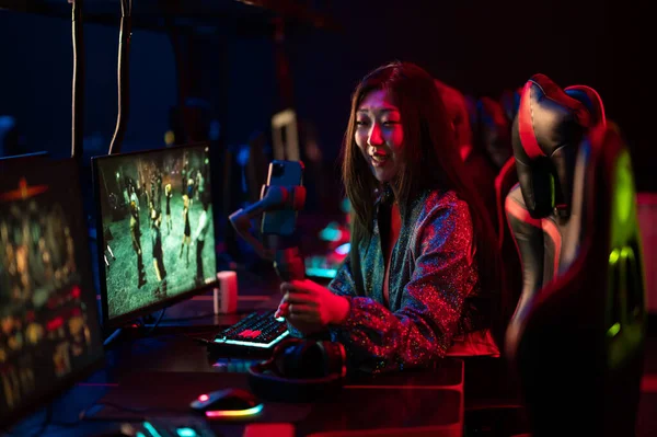 A young chinese gamer participates in esports competitions. Conducts an online broadcast and stream on a social network. Gimbal and smartphone. — Stock Photo, Image