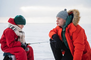 Baba ve oğul kışın kırmızı elbiseleriyle nehir kıyısında balık tutmaya gelirlerdi.