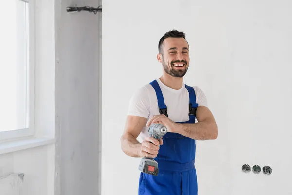 Construtor posando com uma broca em suas mãos e sorrindo — Fotografia de Stock