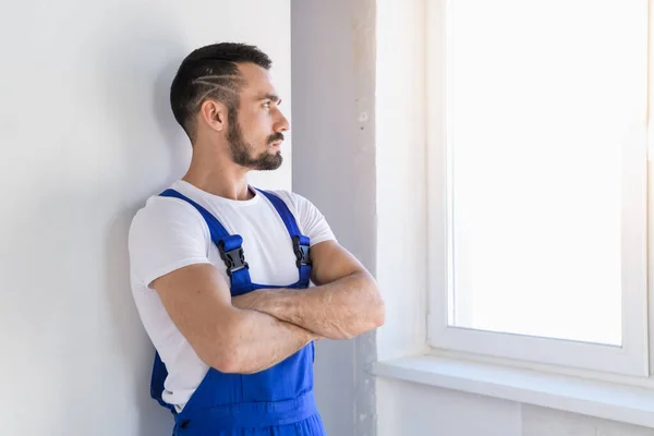 Handyman i overaller vikta armarna över bröstet — Stockfoto