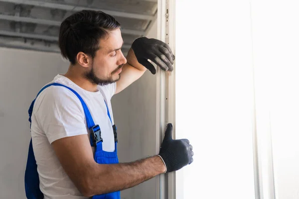 L'operaio installa un telaio della finestra nella stanza — Foto Stock