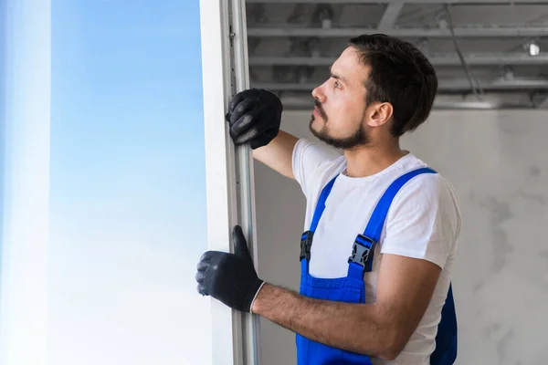 Pracownik w rękawiczkach instaluje okno w mieszkaniu — Zdjęcie stockowe