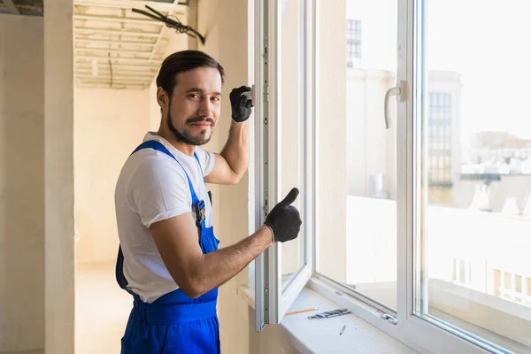 Der junge Justierer steht am offenen Fenster — Stockfoto