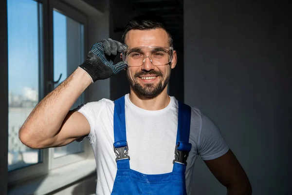 Förmannen i handskar och glasögon ler vänligt — Stockfoto