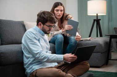 Uzak bir ofisten bir adam ve bir kadın ev ofisinden yoğun telefon görüşmeleri yapıyorlar, tecrit sırasında koltuğun yanında ve yanında oturuyorlar.