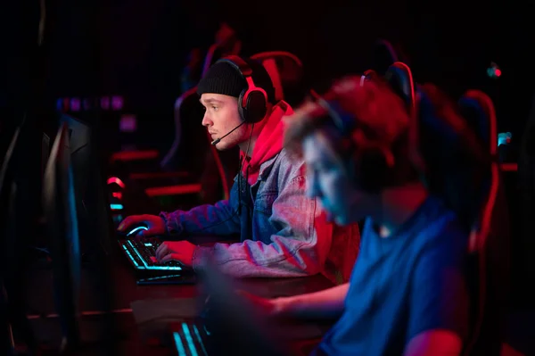 International gaming event. Arena for conducting esports competitions. Young players with headphones are playing a popular online game. — Stock Photo, Image