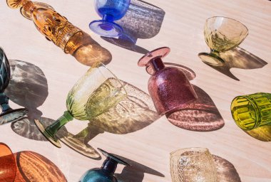 Beyaz bir masada renkli gözlüklerle gölge oyunu